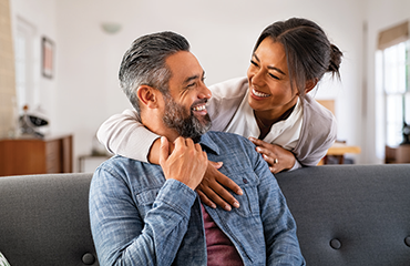 Smiling couple embracing each other in the living room.