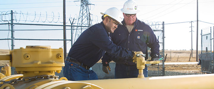 Two SMUD employees work on a gas pipeline.